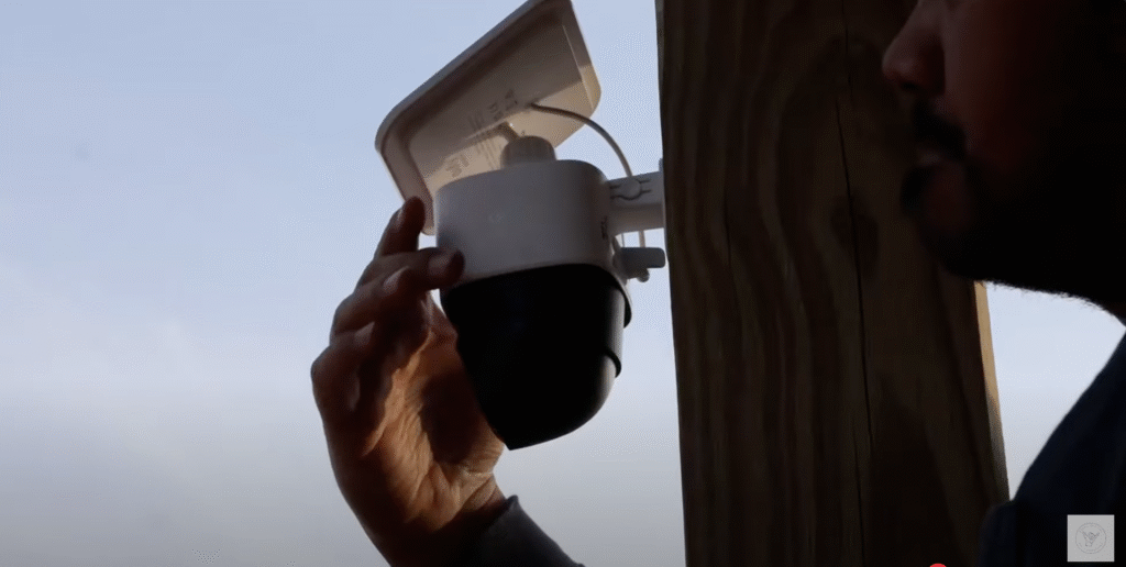 Installing the Eufy SoloCam S340 security camera on a wooden post at sunset